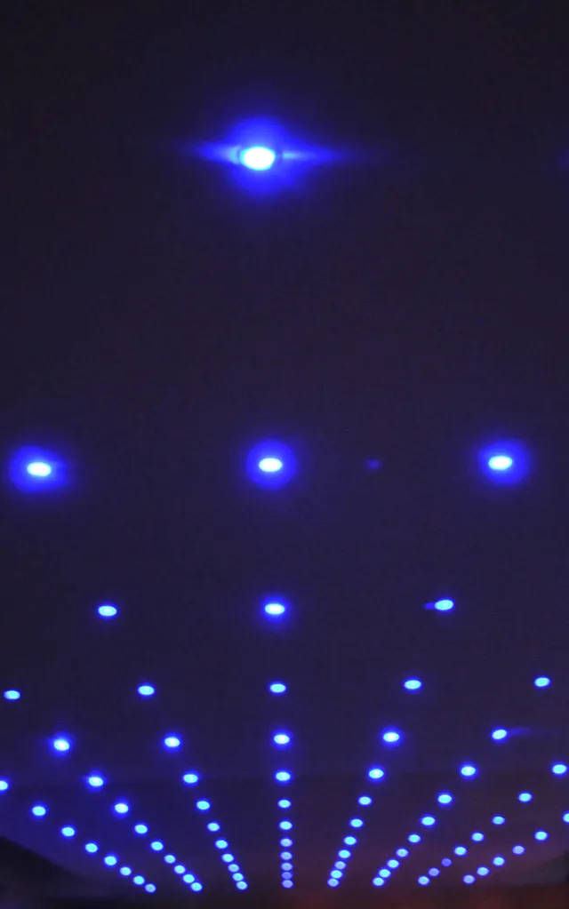 Blue beams of light cutting across a dark venue